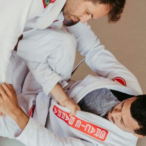 White Brazilian Jiu-Jitsu gi with white belt on white background